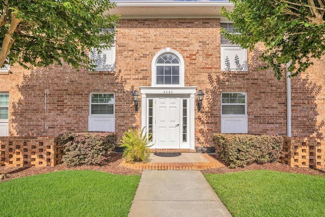 4262 Lake Underhill Rd Unit 9C7, Orlando, FL 32803 - doorway to property featuring a yard and brick siding