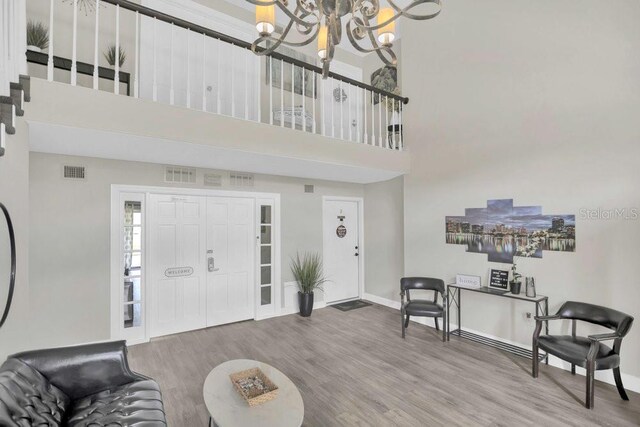 4262 Lake Underhill Rd Unit 9C7, Orlando, FL 32803 - foyer entrance featuring a chandelier, a high ceiling, wood finished floors, and baseboards