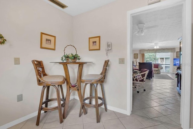 4262 Lake Underhill Rd Unit 9C7, Orlando, FL 32803 - dining room featuring baseboards, light tile patterned floors, and a ceiling fan