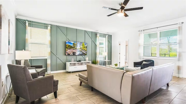 living area featuring baseboards, a ceiling fan, and light tile patterned flooring