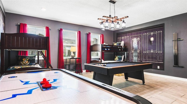 playroom with a textured ceiling, an inviting chandelier, billiards, and baseboards