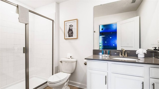 full bathroom featuring toilet, baseboards, a shower stall, and vanity