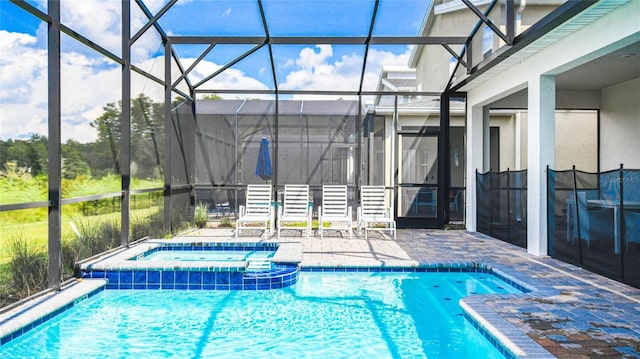 view of swimming pool featuring a patio, a lanai, and a pool with connected hot tub