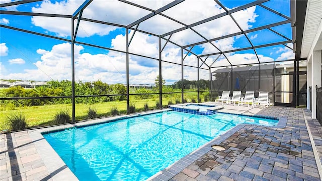 view of pool with glass enclosure, a pool with connected hot tub, and a patio area