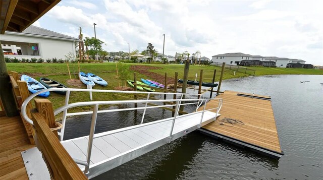dock area with a lawn and a water view