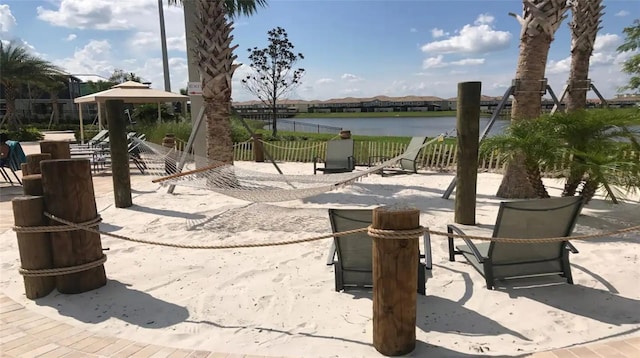 view of patio / terrace featuring fence and a water view