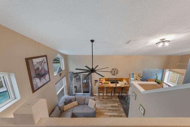 living area with wood finished floors and ceiling fan