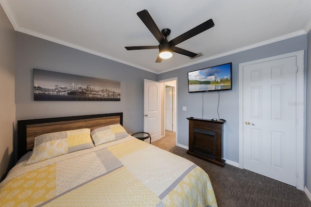 carpeted bedroom featuring visible vents, a fireplace, crown molding, a ceiling fan, and baseboards
