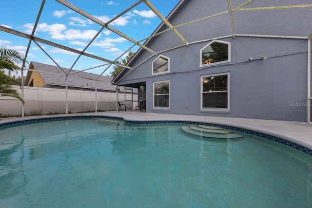 view of swimming pool featuring a patio area, glass enclosure, a fenced in pool, and fence