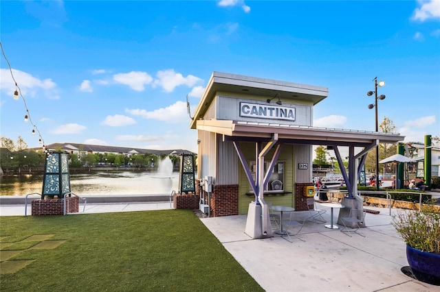exterior space featuring a lawn and a water view