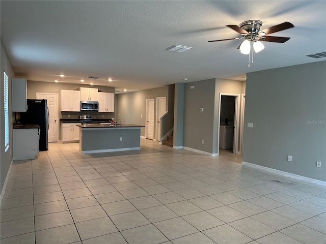 13344 Great Plains Dr S, Riverview, FL 33579 - kitchen featuring visible vents, dark countertops, baseboards, an island with sink, and stainless steel appliances