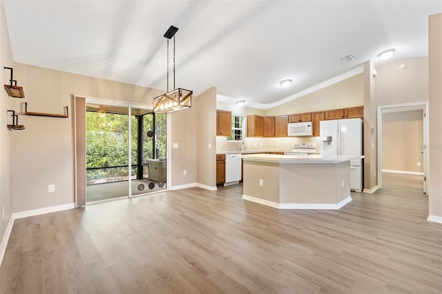 kitchen with lofted ceiling, a kitchen island, white appliances, light countertops, and brown cabinets
