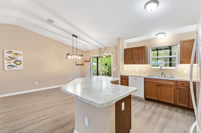 kitchen with light wood-style floors, white dishwasher, light countertops, a sink, and vaulted ceiling