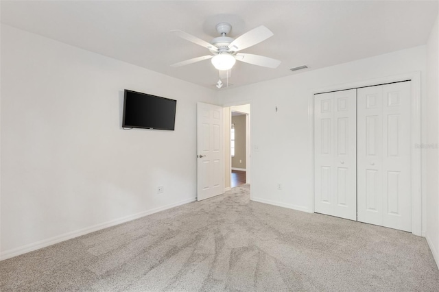 unfurnished bedroom featuring a ceiling fan, visible vents, baseboards, a closet, and carpet flooring