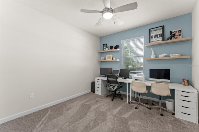 carpeted home office featuring baseboards and ceiling fan