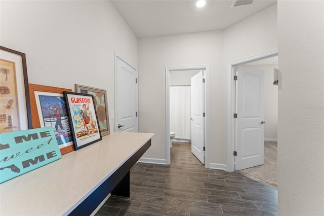 hallway with baseboards, visible vents, and wood tiled floor