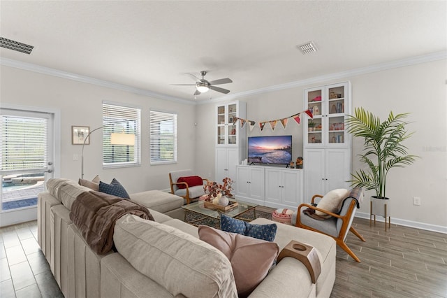 living area with visible vents, ornamental molding, and a healthy amount of sunlight