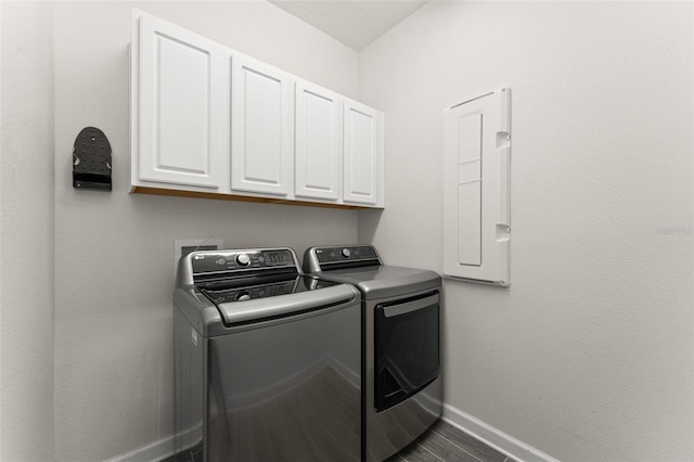 laundry room featuring cabinet space, baseboards, and washer and clothes dryer