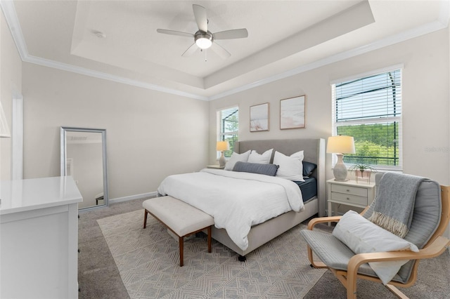 bedroom featuring crown molding, a ceiling fan, light colored carpet, and a raised ceiling