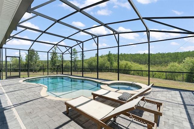 view of pool with a fenced backyard, a patio, a pool with connected hot tub, and glass enclosure