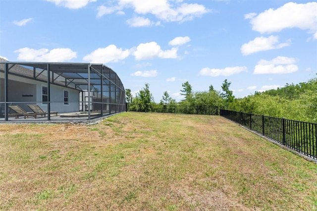 view of yard featuring glass enclosure, a patio, and a fenced backyard