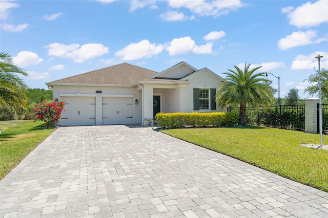 single story home with decorative driveway, fence, a front yard, and a garage