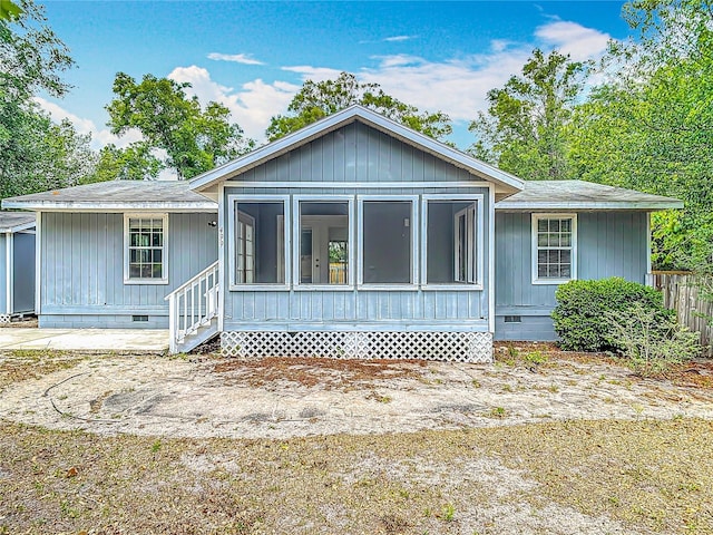 499 W Beresford Rd, Deland, FL 32720 - view of front of home featuring crawl space, a sunroom, a shingled roof, and fence