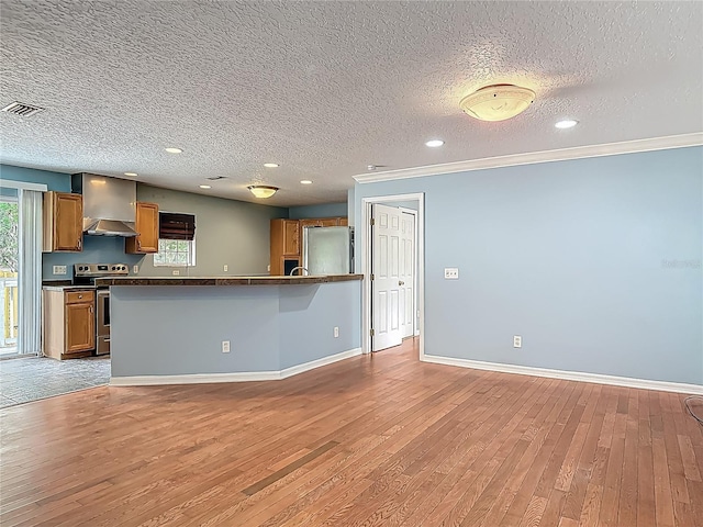 499 W Beresford Rd, Deland, FL 32720 - kitchen featuring stainless steel appliances, dark countertops, brown cabinets, light wood-style floors, and a textured ceiling