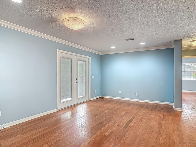 499 W Beresford Rd, Deland, FL 32720 - unfurnished room with hardwood / wood-style flooring, ornamental molding, a textured ceiling, baseboards, and french doors