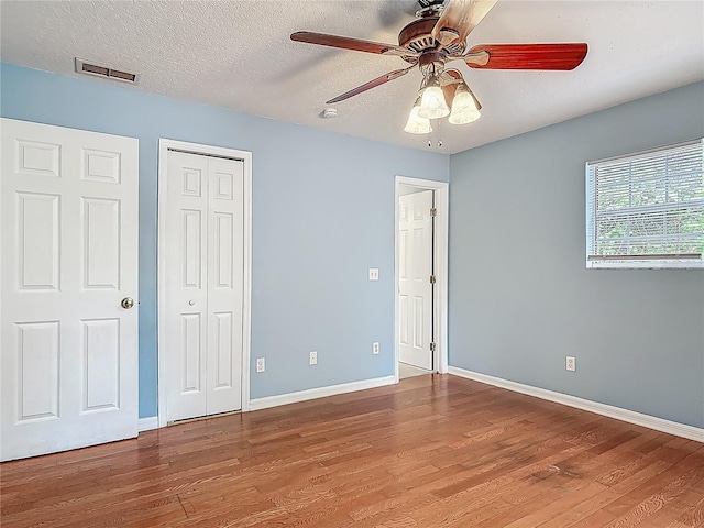 499 W Beresford Rd, Deland, FL 32720 - unfurnished bedroom featuring wood finished floors, baseboards, a closet, and a textured ceiling
