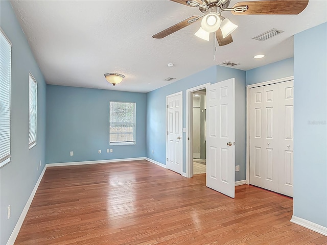 499 W Beresford Rd, Deland, FL 32720 - unfurnished bedroom featuring light wood-type flooring, baseboards, a textured ceiling, ceiling fan, and a closet