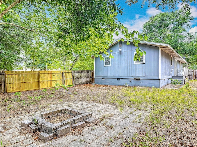 499 W Beresford Rd, Deland, FL 32720 - rear view of house featuring crawl space, a fenced backyard, and an outdoor fire pit