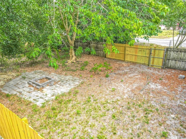 499 W Beresford Rd, Deland, FL 32720 - view of yard featuring a fire pit, fence, and a gate