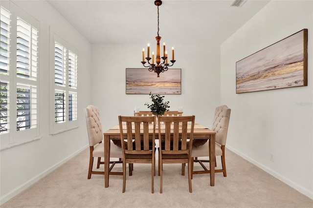 dining room with baseboards, light colored carpet, and a chandelier