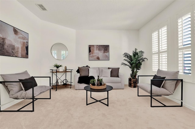 carpeted living room with baseboards and visible vents