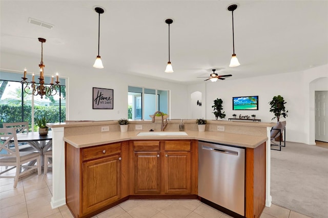 kitchen featuring stainless steel dishwasher, visible vents, light countertops, arched walkways, and a sink