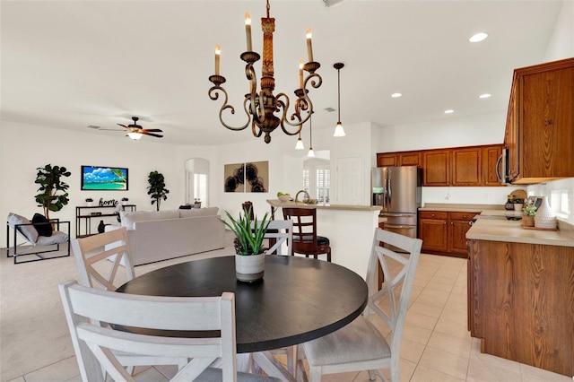 dining area with arched walkways, ceiling fan with notable chandelier, recessed lighting, and light tile patterned flooring