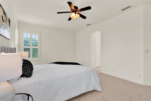 bedroom with baseboards, visible vents, light carpet, and ceiling fan