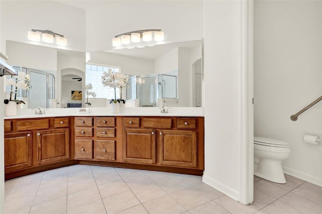 bathroom featuring a sink, a shower stall, and double vanity