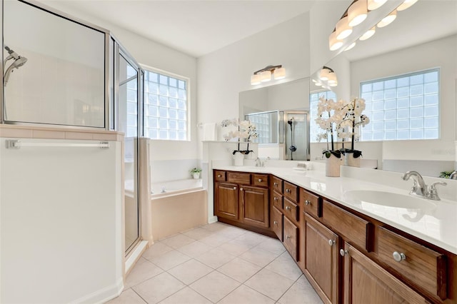 full bath featuring plenty of natural light, tile patterned floors, a garden tub, and a stall shower