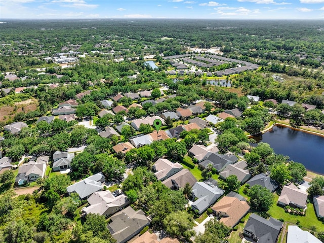 drone / aerial view featuring a water view, a view of trees, and a residential view