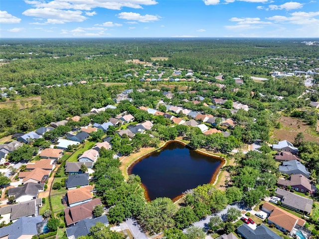 drone / aerial view with a water view, a view of trees, and a residential view