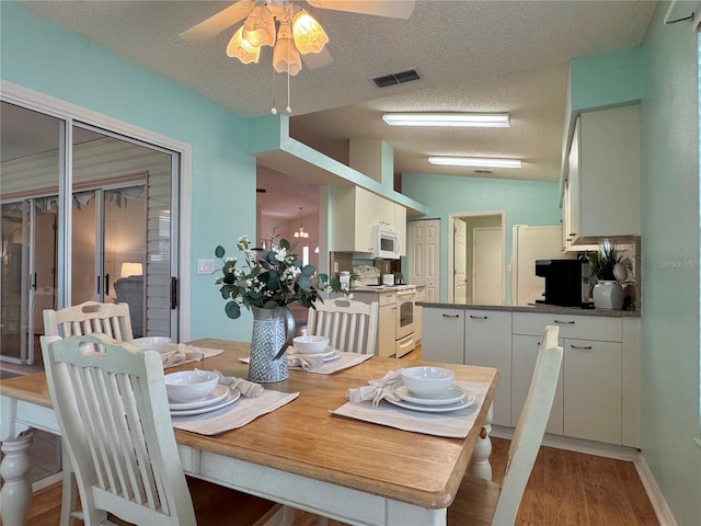 32900 Crooked Oaks Ln, Leesburg, FL 34748 - dining space with a textured ceiling, ceiling fan, light wood-type flooring, and vaulted ceiling