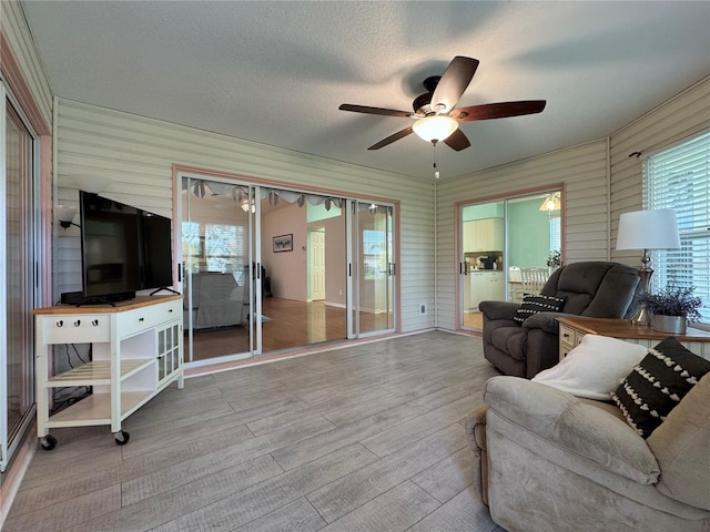 32900 Crooked Oaks Ln, Leesburg, FL 34748 - living room with ceiling fan, wood finished floors, healthy amount of natural light, and a textured ceiling