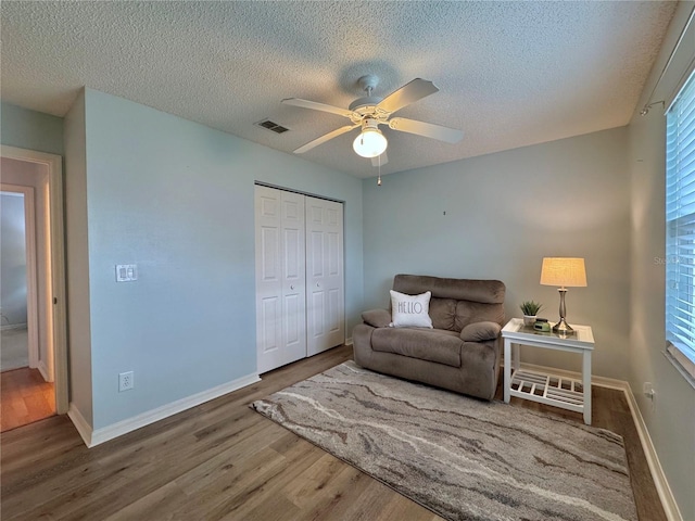 32900 Crooked Oaks Ln, Leesburg, FL 34748 - sitting room featuring a textured ceiling, wood finished floors, ceiling fan, and baseboards