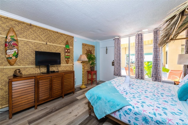 2043 S Atlantic Ave Unit 105, Daytona Beach Shores, FL 32118 - bedroom with ornamental molding, wood finished floors, a wall of windows, baseboards, and a textured ceiling