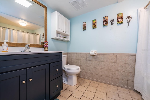 2043 S Atlantic Ave Unit 105, Daytona Beach Shores, FL 32118 - full bath featuring tile patterned flooring, toilet, a wainscoted wall, tile walls, and visible vents