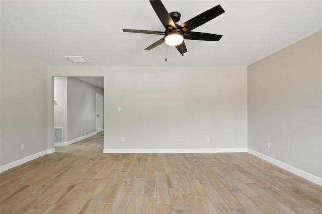 spare room with ceiling fan, visible vents, baseboards, and light wood-style floors
