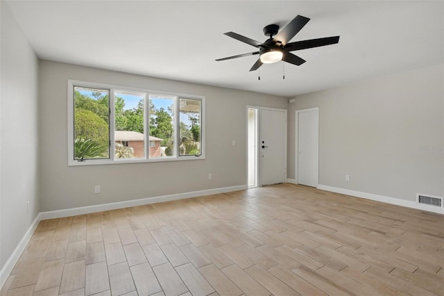 unfurnished room with light wood-style floors, baseboards, a ceiling fan, and visible vents