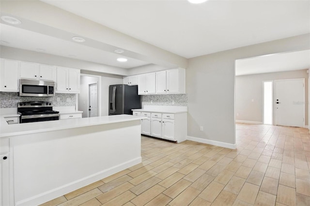 kitchen featuring light countertops, appliances with stainless steel finishes, white cabinets, and backsplash